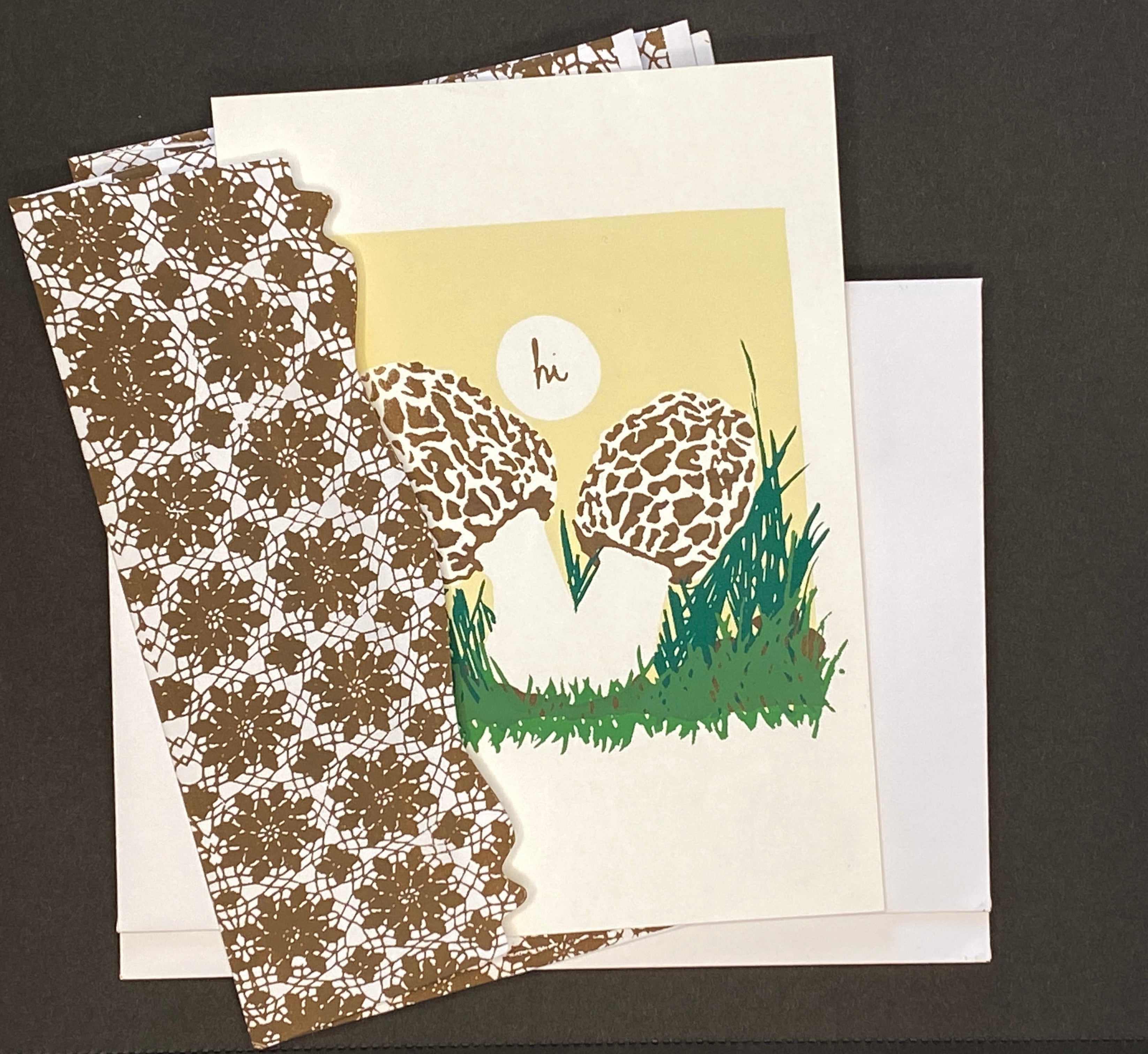 Greeting Card with two morel mushrooms and a 'hi' bubble on a pale yellow background with coordinating hand printed envelopes
